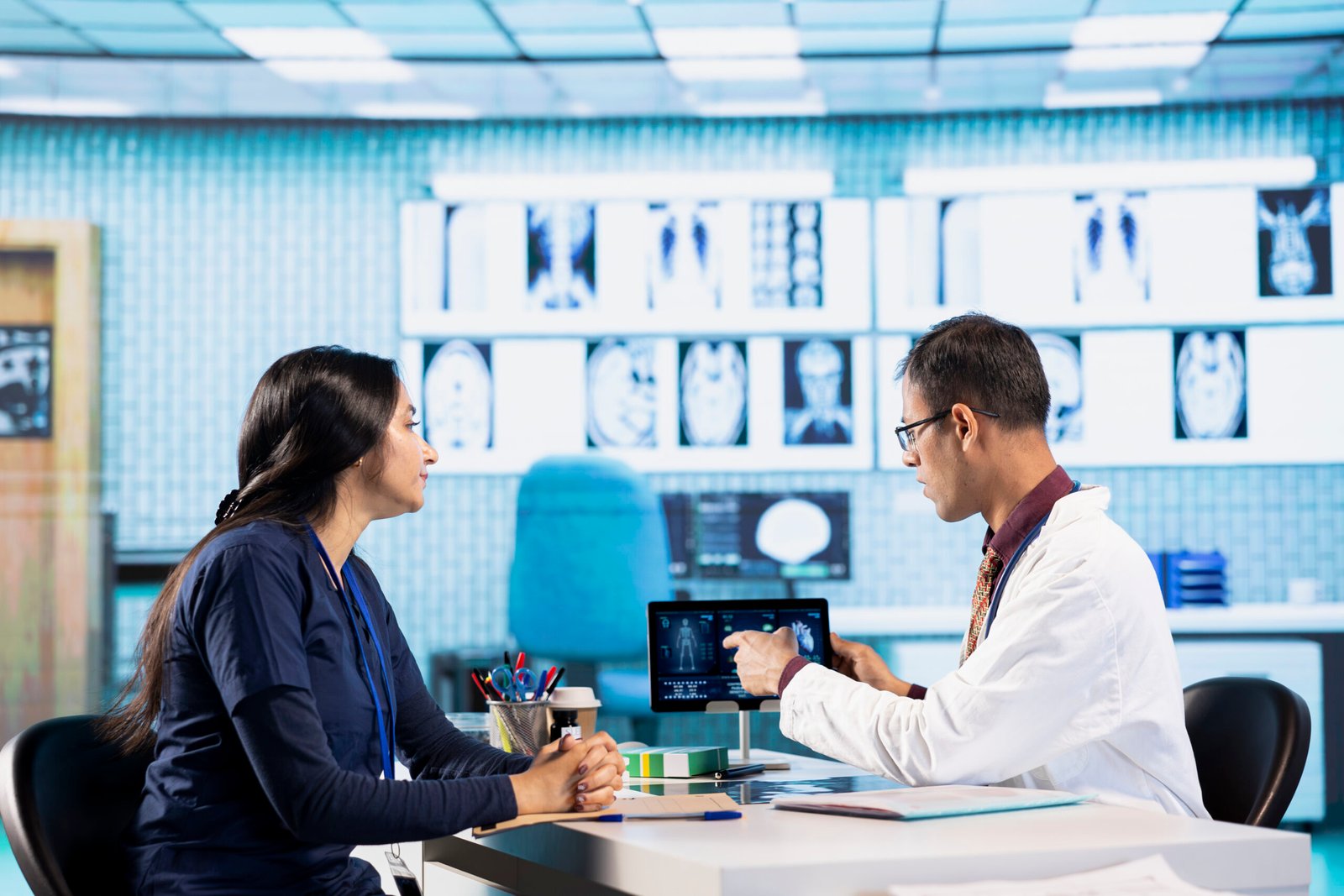 General practitioner consulting patient and reviewing x ray test results, utilizing technology for accurate analysis and patient care management in a medical environment. Healthcare provider.